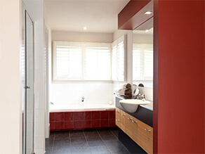 Red Tile Bathroom with Bathtub and Tile Floor and Sink and Black Basin